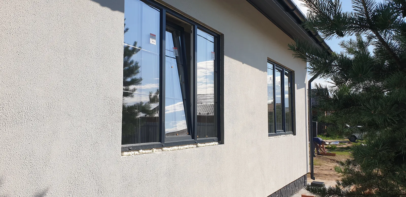 Тёмные окна в оштукатуренном загородном доме